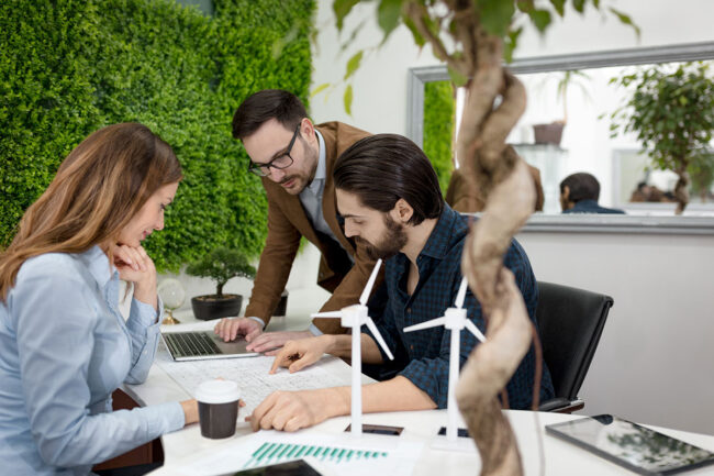 smart-qualified-skilled-young-engineers-looking-project-alternative-energy-with-miniatures-windmill-turbines-table sun4u - Il green job: in crescita la richiesta di competenze nel settore green.