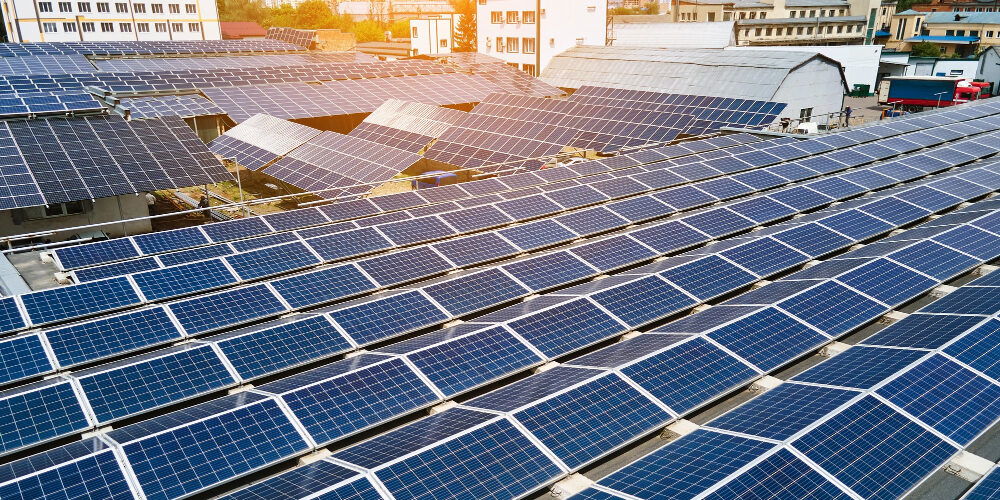 aerial-view-blue-photovoltaic-solar-panels-mounted-industrial-building-roof-producing-green-ecological-electricity-production-sustainable-energy-concept SUN4U - FACCIAMO IL PUNTO SULLE CER CON LEGAMBIENTE e GSE